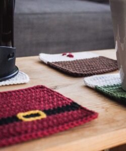 Four cute crochet Christmas coasters in use