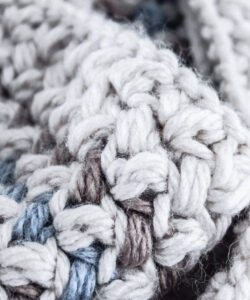 Close up mini bean stitch crochet cowl in cream, brown and pale blue