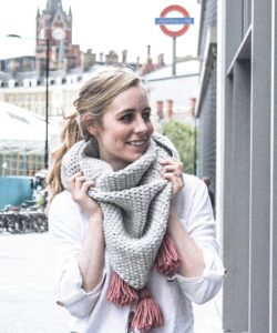 Oversized crochet triangle scarf in grey with pink tassels, worn at Kings Cross London