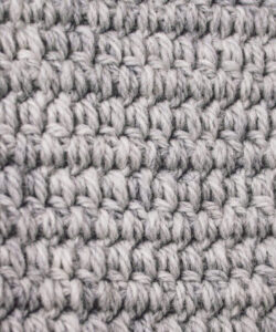 Close up of crochet stitches in grey 100% wool yarn